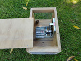 DOC200 trap for rat, stoat, and hedgehog control, sitting in wooden housing.