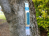 A Feracol Striker for possum and rat control, stapled onto a tree.