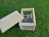 DOC250 trap for ferret, stoat, rat, and hedgehog control, sitting in wooden housing.