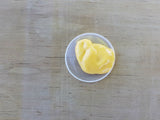 Eggsellent non-toxic lure for possum, rat, and stoat control - a small amount of yellow lure in a dish.