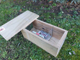 DOC150 trap for rat, stoat, and hedgehog control, sitting in wooden housing.